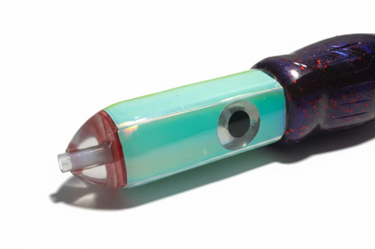 Close-up of a translucent iridescent green and blue cylindrical product with a black textured handle, resting on a beige fabric surface.
